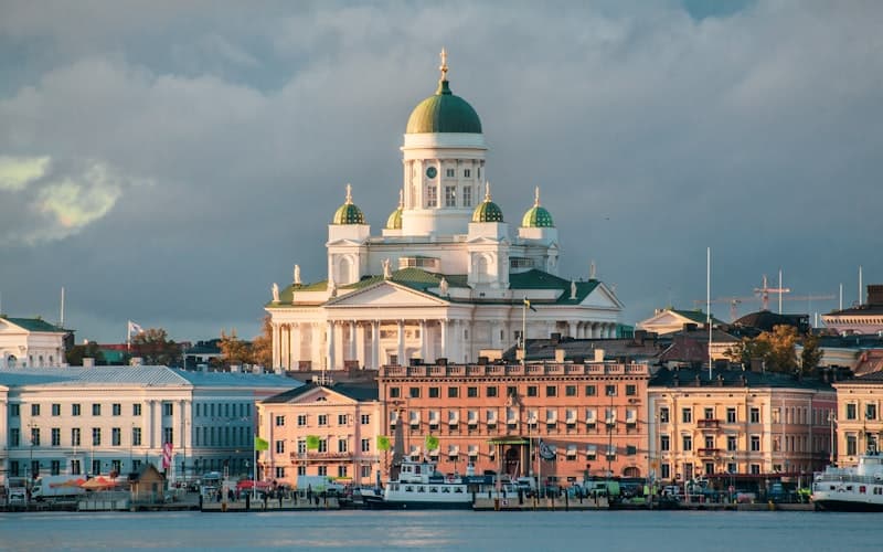 Vihreäkupolinen valkoinen katedraali kohoaa satama-altaan ja vaaleiden talojen yllä.