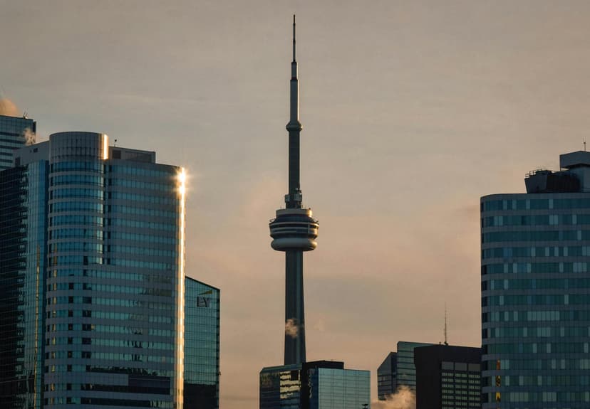 The Toronto skyline with the CN Tower glowing against a dusk sky over Lake Ontario