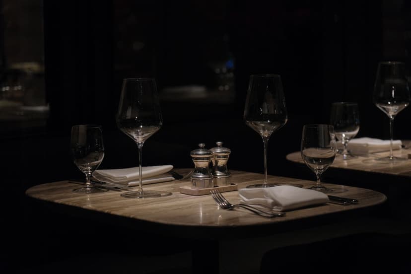 The candlelit interior of an upscale restaurant in the evening, set for a quiet dinner