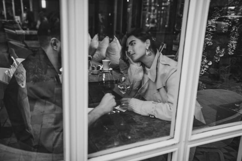 Paar im Gespräch an einem Restauranttisch am Fenster, Schwarz-Weiß-Aufnahme