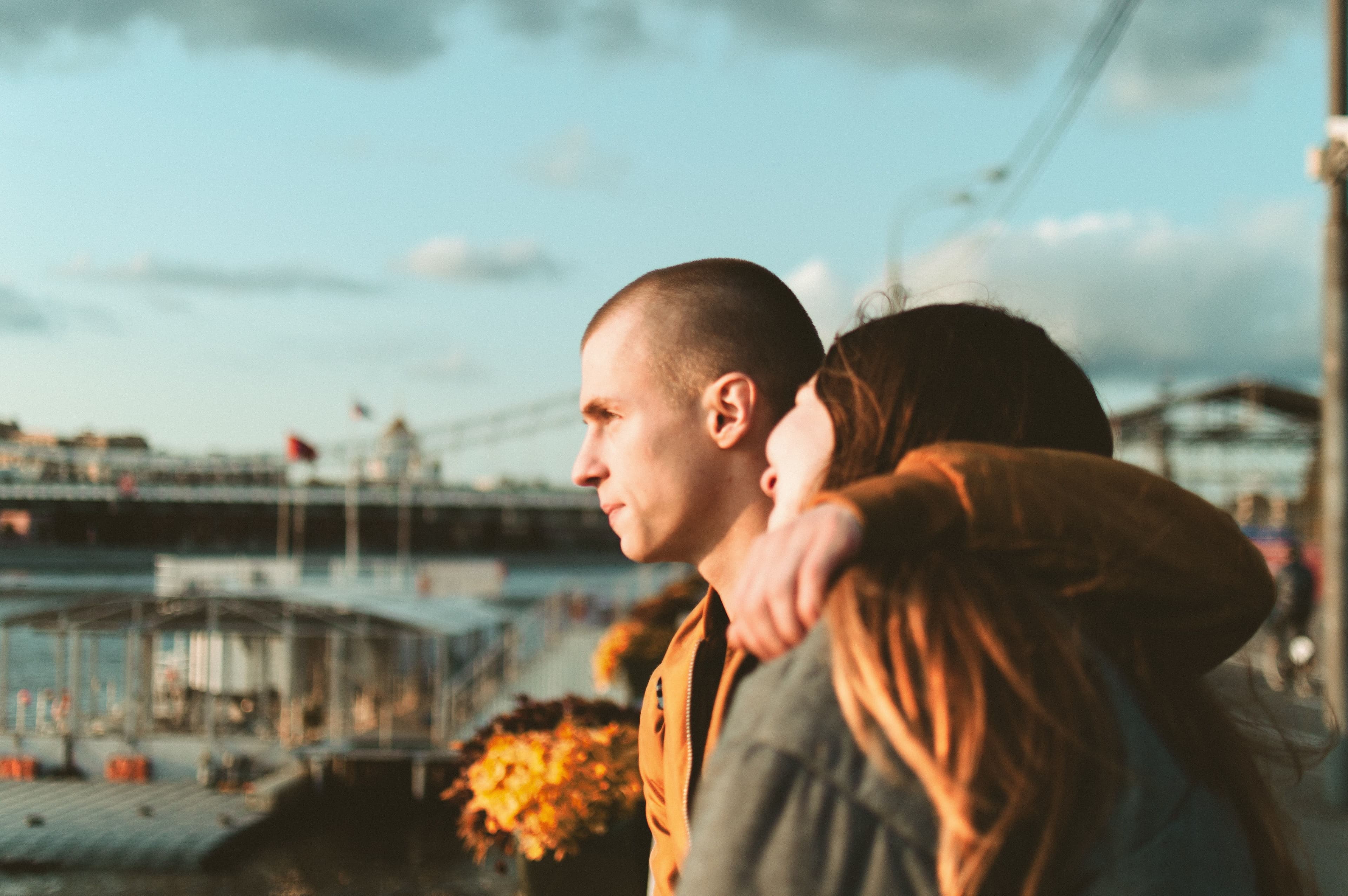 Par står sammen og kigger ud over byen ved solnedgang som symbol på moderne kærlighedssprog, nærhed og udvikling i dating og sugardating.