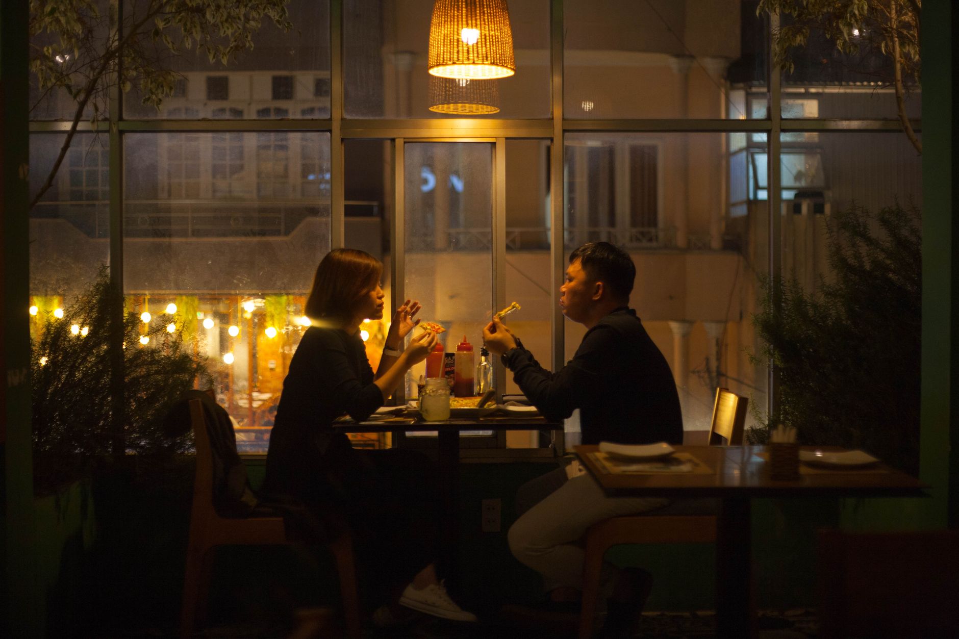 A couple dining together at a warm, candlelit table in an intimate fine-dining restaurant