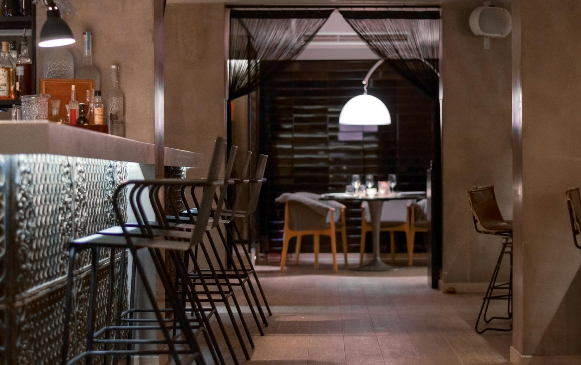 The interior of a refined cocktail bar bathed in soft, dim ambient lighting